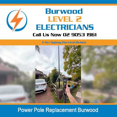Electricians working on power pole replacement on residential street in Burwood
